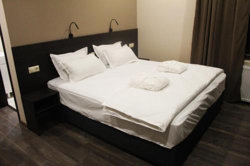 a bed with white sheets and two towels on it at Milky Way in Stepantsminda