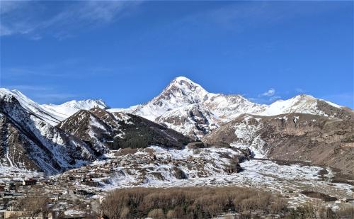 a snow covered mountain range with snow covered mountains at Milky Way in Stepantsminda