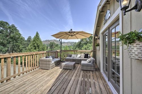 a wooden deck with a couch and an umbrella at Family Home Near Kings and Sequoia National Parks! in Squaw Valley
