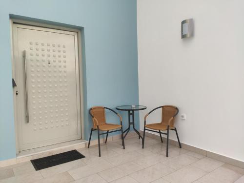 two chairs and a table in a room at Armonia Studios Preveza in Preveza