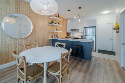 a kitchen and dining room with a white table and chairs at Condo Old Quebec - Gym - AC - Indoor Parking - Rooftop in Quebec City