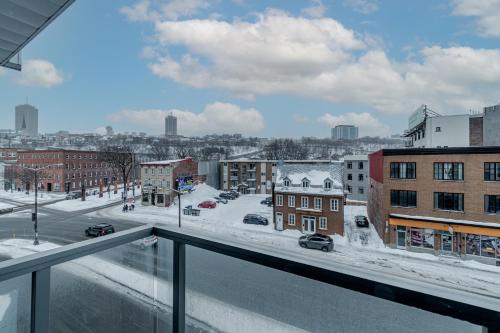 a view of a city in the snow from a balcony at Condo Old Quebec - Gym - AC - Indoor Parking - Rooftop in Quebec City