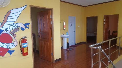 ein Badezimmer mit einem Feuerlöscher an der Wand in der Unterkunft Phatra Hostel in Thongsala