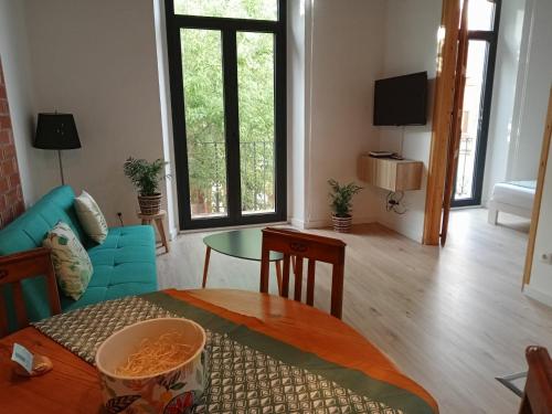 ein Wohnzimmer mit einem blauen Sofa und einem Tisch in der Unterkunft CAN LLAVI - LLAUT in Canet de Mar