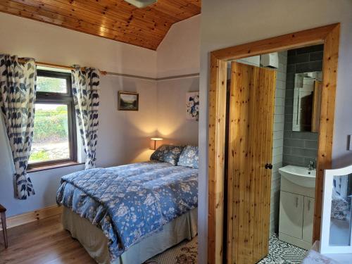 a bedroom with a bed and a window and a sink at Kate's Cottage in Valentia Island