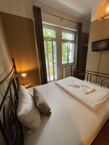 a bedroom with a large white bed with a window at AUERSTEIN-Hotels auerstein & auerstein-mono in Heidelberg