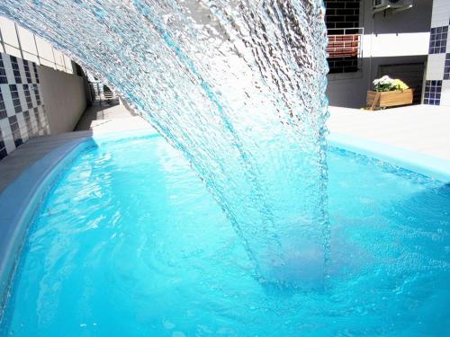 uma fonte de água no meio de uma piscina em POUSADA JURERE em Florianópolis