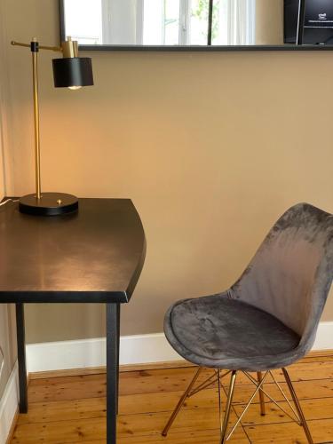 a chair next to a table with a lamp at AUERSTEIN-Hotels auerstein & auerstein-mono in Heidelberg