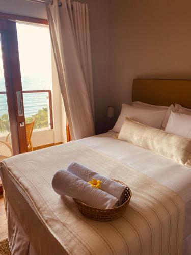 a basket with a flower in it sitting on a bed at Beach Eco Stays Hotel Boutique Lagoinha in Tigre
