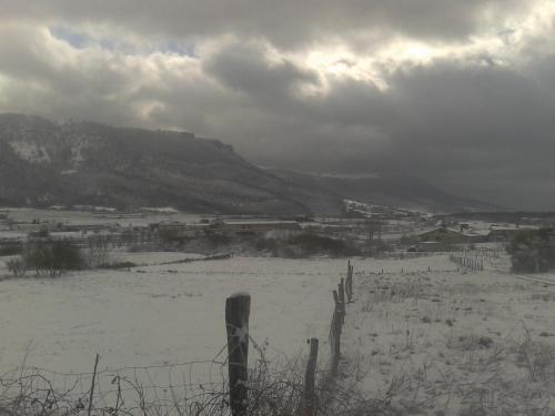 a snowy field with a fence and a mountain at Apartamento Rural Arluzepe in Echarri-Aranaz