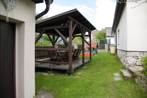 a wooden deck with a picnic table in a yard at Hezká chalupa in Strmilov