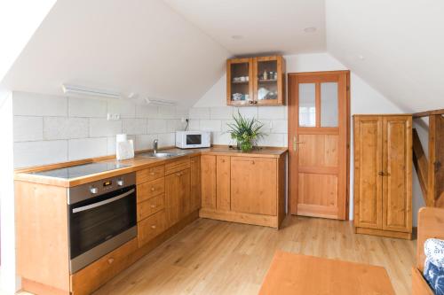 a kitchen with wooden cabinets and a stove top oven at Hezká chalupa in Strmilov