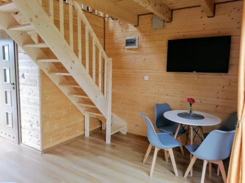 a room with a table and chairs and a tv at Brzozowa Polana in Perlino
