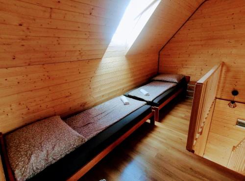 a room with two beds in a wooden cabin at Brzozowa Polana in Perlino