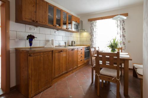 a kitchen with wooden cabinets and a table and chairs at Hezká chalupa in Strmilov