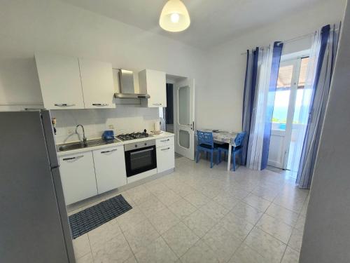 a kitchen with white cabinets and a stove top oven at Casa vacanze Lino e Iolanda in Pollara