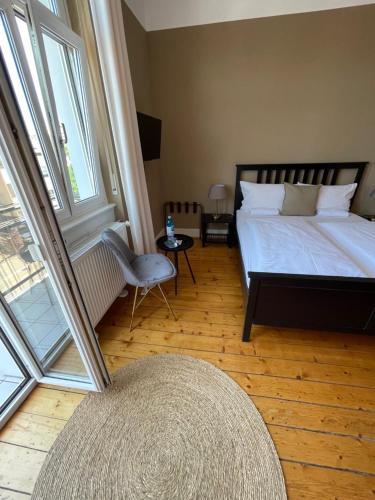 a bedroom with a bed and a chair and a window at AUERSTEIN-Hotels auerstein & auerstein-mono in Heidelberg