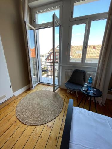 a living room with a large window and a rug at AUERSTEIN-Hotels auerstein & auerstein-mono in Heidelberg