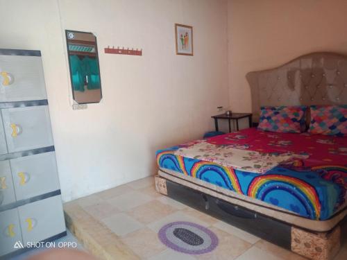 een slaapkamer met een bed met een kleurrijk dekbed bij Salty Dog Hostel in Telukdalem