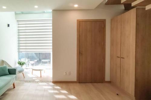 a living room with a wooden door and a couch at Onkel Inn Apart Suites in La Paz