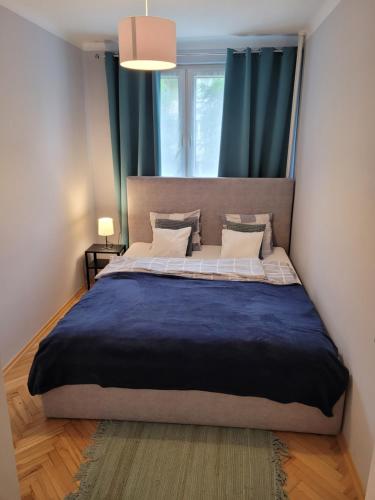 uma cama grande num quarto com cortinas azuis em Apartament City Center em Lańcut