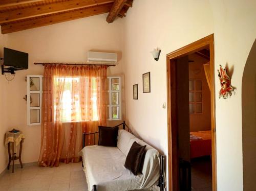 a living room with a couch and a window at Palma Sidari Corfu in Sidari