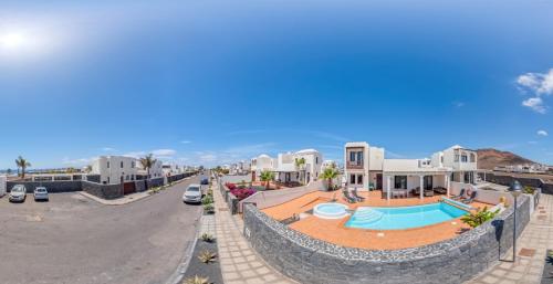 Vistas al mar de una calle con casas y una piscina en Villa Sunset Faro Deluxe & Spa Pool, en Playa Blanca