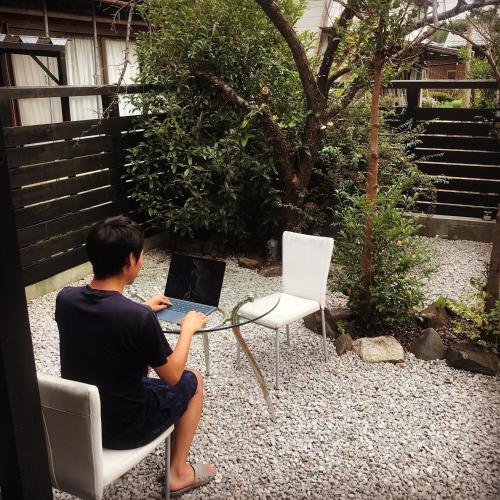 un hombre sentado en una mesa con un ordenador portátil en Kishida House - Vacation STAY 78228v, en Nagahama