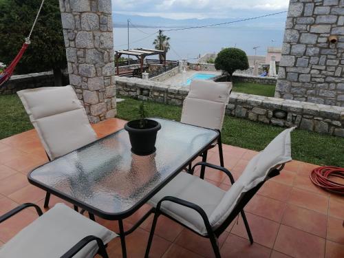 a table and chairs on a patio with a pool at Malvazios Villas #8 in Gythio