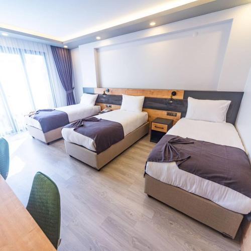 a hotel room with three beds and a table at ÇAMLICA PARK OTEL in Of