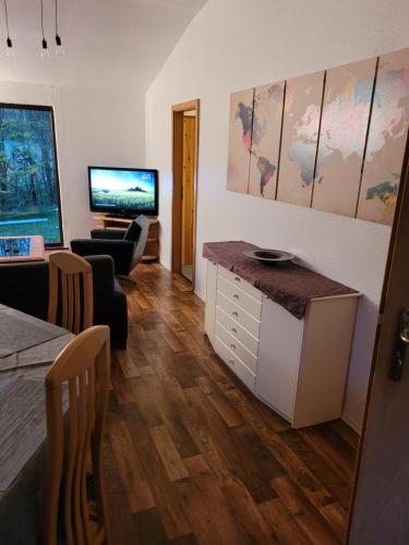 a living room with a table and a television at Grüne Haus in Vöhl