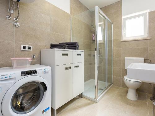 a bathroom with a washing machine and a toilet at Apartment Anna in Poreč