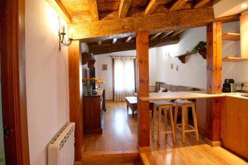 cocina con vigas de madera y barra con taburetes en Apartamento El Salvador, en Cuenca