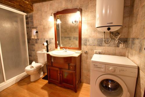 y baño con lavabo y lavadora. en Apartamento El Salvador, en Cuenca