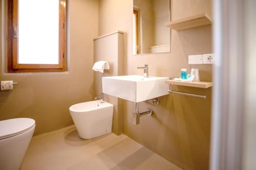 La salle de bains est pourvue d'un lavabo et de toilettes. dans l'établissement Hotel Il Perseo, à Chiessi