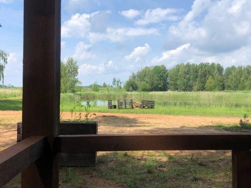 a view of a field from a wooden fence at Forest cabin in Ozolaine