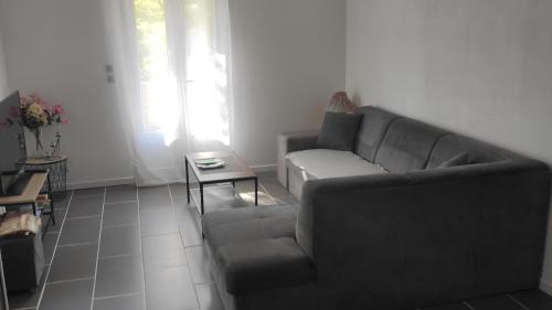 a living room with a couch and a table at Apartement 'les lavandes" RdC 2CH - terrasse et parking à Lurs in Lurs