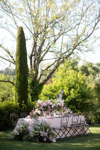a white table with flowers on it in a park at Relais Sassa al Sole in San Miniato