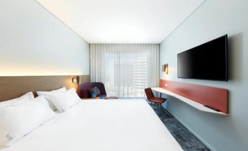a hotel room with a bed and a flat screen tv at Holiday Inn Express Sydney Airport by IHG in Sydney