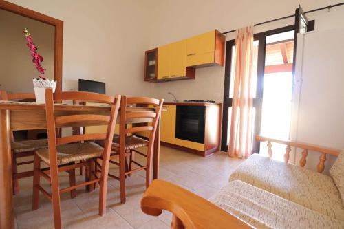 a kitchen and dining room with a table and chairs at Agriturismo Monte Istulargiu in Valledoria