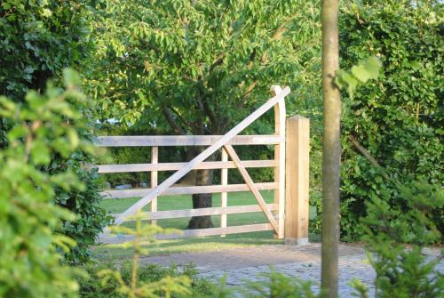 a wooden gate in the middle of a garden at 't Poorthof in Borgloon