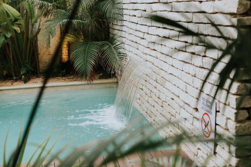 a water fountain in a brick wall at The Strabon Tulum in Tulum