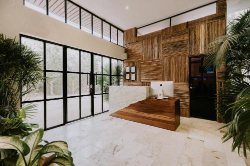 a lobby with a desk and large windows at The Strabon Tulum in Tulum