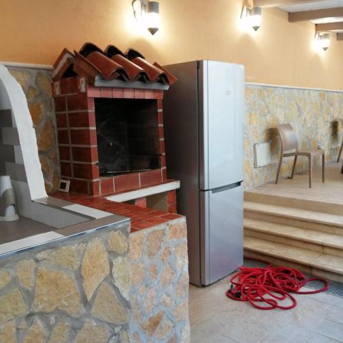 uma cozinha com um frigorífico e um forno de tijolo em Ivana home em Trapani
