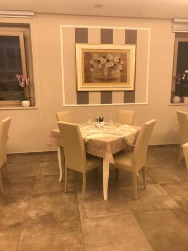 a dining room with a table with chairs and a painting at Bistrot Ventidue agriturismo e B&B in Mirabella Eclano