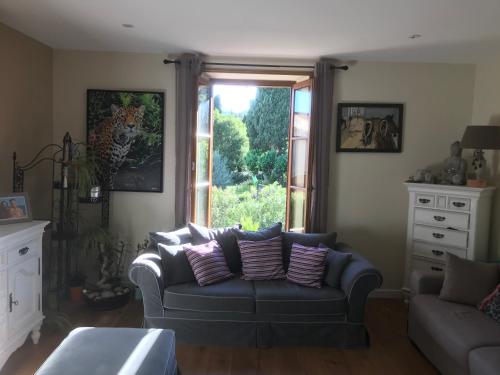 a living room with a couch and a window at La LAZARENCO in Plan-de-la-Tour