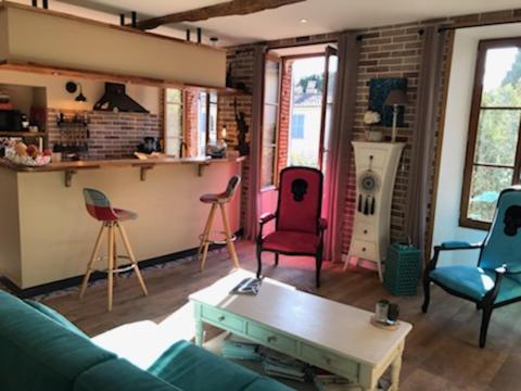 a living room with colorful chairs and a table at La LAZARENCO in Plan-de-la-Tour