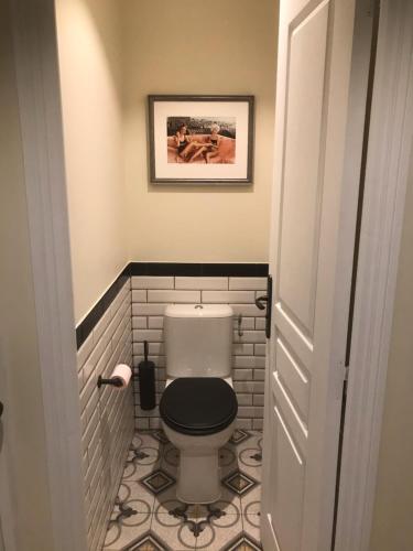 a bathroom with a toilet with a black seat at La LAZARENCO in Plan-de-la-Tour