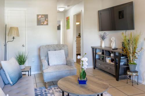 a living room with a tv and a chair and a table at Congeniality and Comfort. All the essentials with class, 2 nights? 2 weeks? Stay, relax, work, or go out for fun. in Arlington