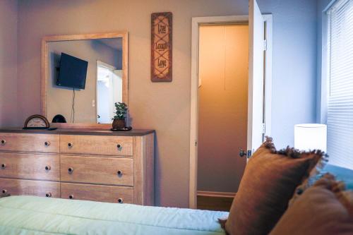 a bedroom with a bed and a dresser and a mirror at Congeniality and Comfort. All the essentials with class, 2 nights? 2 weeks? Stay, relax, work, or go out for fun. in Arlington